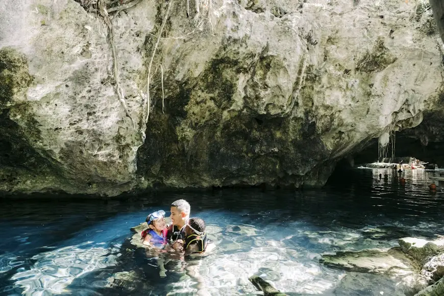 Familia nadando en un cenote de la Riviera Maya, México