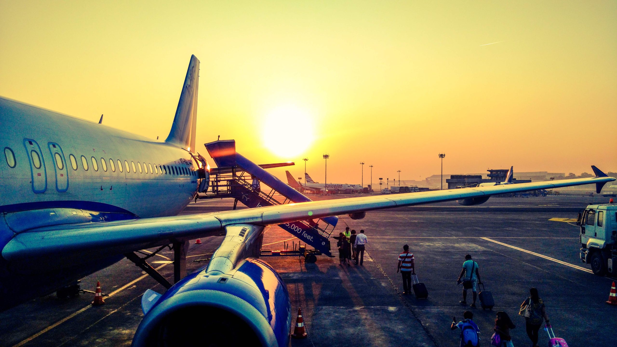 A plane wing and passengers getting on board