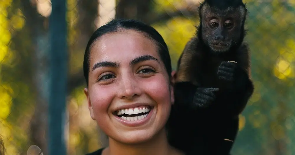headshot of a girl with a monkey on her shoulder